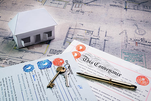 Property and Mortgage deeds sit on top of plans stock photo