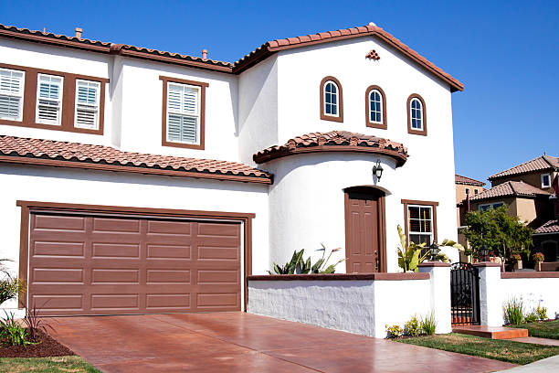 Stucco Home Exterior and Blue Sky Stucco home exterior against a clear blue sky near sunset. Typical Southern California architectural style. Stucco stock pictures, royalty-free photos & images