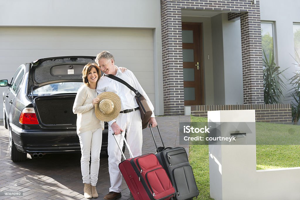 Mature couple with suitcases and car Mature couple with suitcases and car in front of their house Car Stock Photo