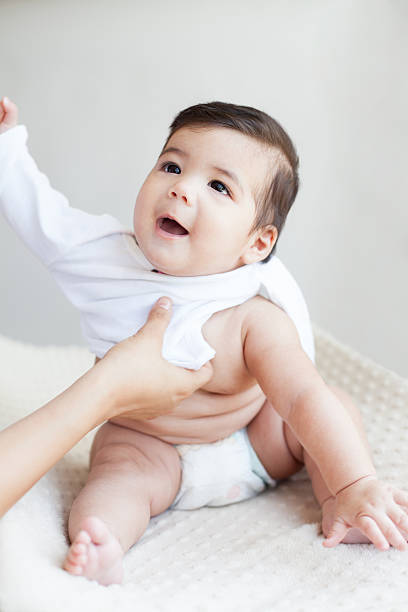 istock Mommy changing baby's clothes 181070237