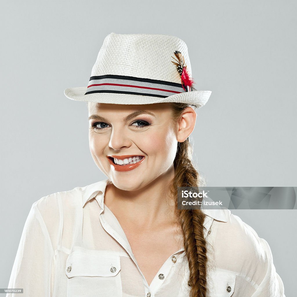 Happiness Portrait of happy young adult woman wearing hat, laughing at camera. Studio shot on grey background. 20-24 Years Stock Photo
