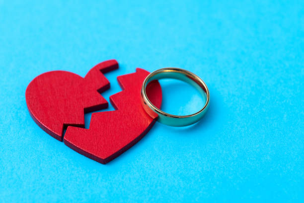 istock Wedding ring with broken heart on blue background 1810702615