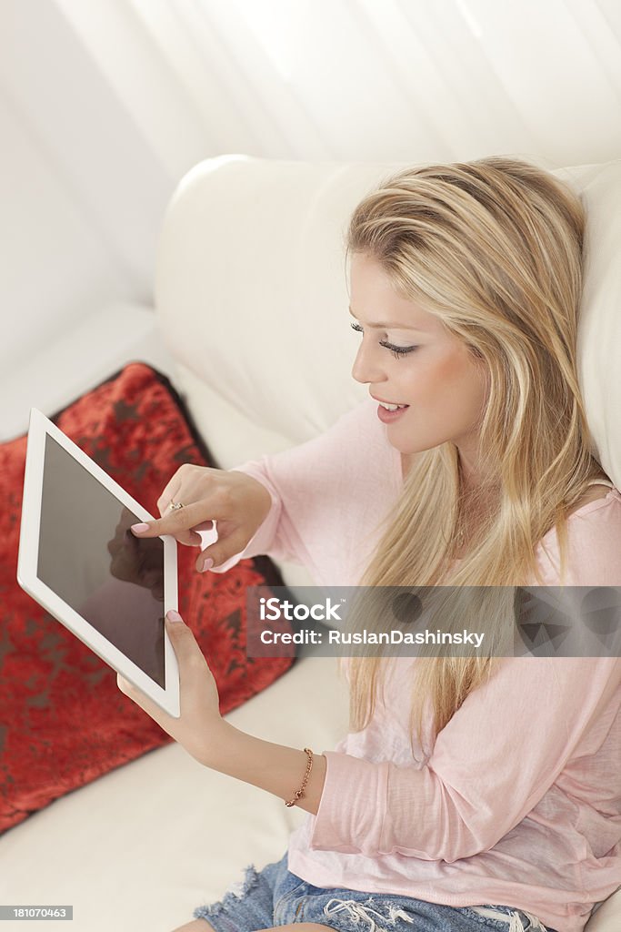 Capelli biondi giovane donna utilizzando computer tablet. - Foto stock royalty-free di Abbigliamento casual