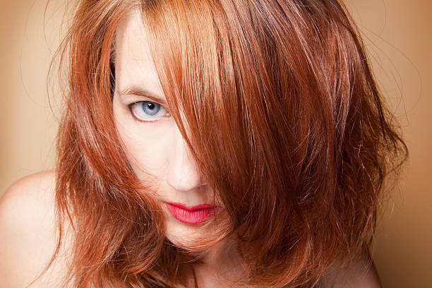 istock Woman Peeking Though Red Messy Hair 181070519