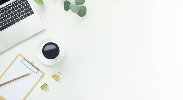 istock Top view office table desk workspace frame with green leaves eucalyptus, clipboard and coffee cup isolated on white background. Flay lay,  ideas, notes or plan writing concept 1810710903