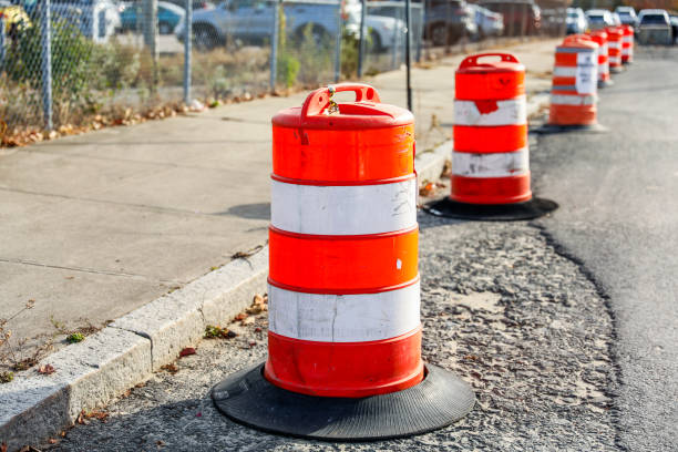 istock orange construction cone on asphalt road with blurred traffic, symbolizing caution and ongoing work in progress 1810710997