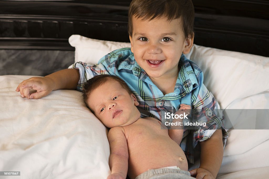 Niño pequeño niño organizar su recién nacido Brother por primera vez - Foto de stock de 0-1 mes libre de derechos