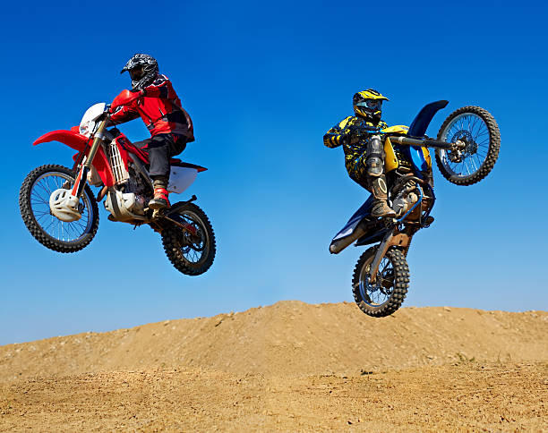 Extreme to the max! Action shot of two dirt bikers jumping in different directions bmx racing stock pictures, royalty-free photos & images