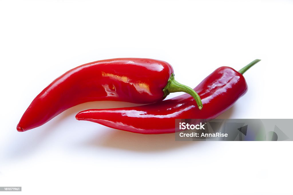 Due red hot chili peppers su sfondo bianco - Foto stock royalty-free di Acqua