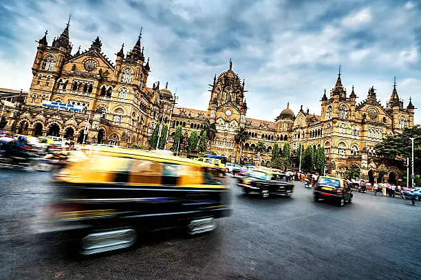 "Vehicles in motion in front of Chhatrapati Shivaji Terminus in Mumbai, India."