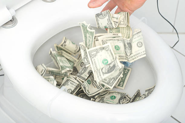 odpady pieniądze, wiele dolarów w toalecie - inflation recession great depression credit crunch zdjęcia i obrazy z banku zdjęć