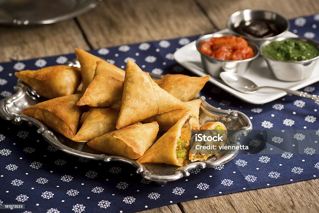 Vegetarian Samosas with Chutney A plate of samosas - a vegetarian dish commonly found in Indian restaurants - with onion-tomato chutney, mint-coriander chutney and tamarind sauce for dipping. Samosa Stock Photo