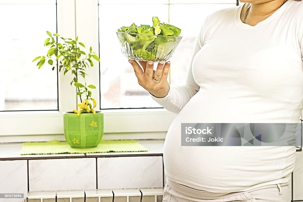 Задумчивый беременная женщина с салатом. - Стоковые фото 25-29 лет роялти-фри