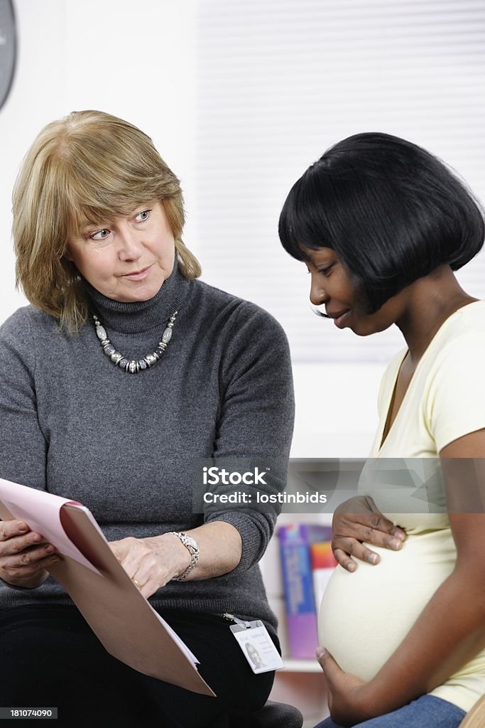 大きな妊娠アフリカ系アメリカ人の女性は、医師の医療に関する注意事項のレビュー - 妊娠のロイヤリティフリーストックフォト