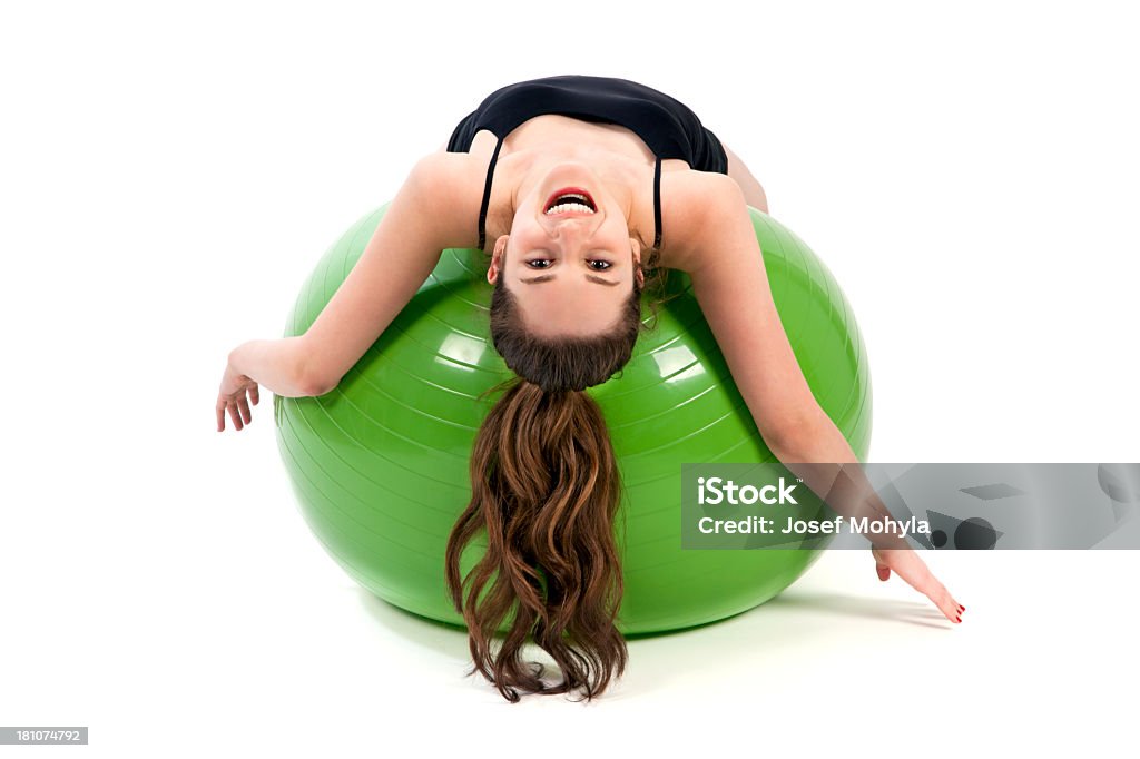 Jeune femme s'étirant son corps sur un ballon de gymnastique - Photo de 18-19 ans libre de droits