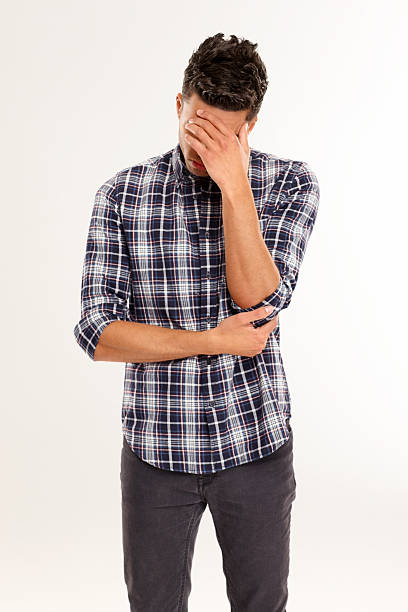 istock Sad young man holding his head in hand 181075199