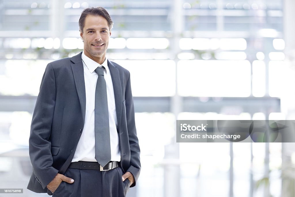 At home in any corporate situation Handsome mature businessman smiling with his hands in his pockets Men Stock Photo