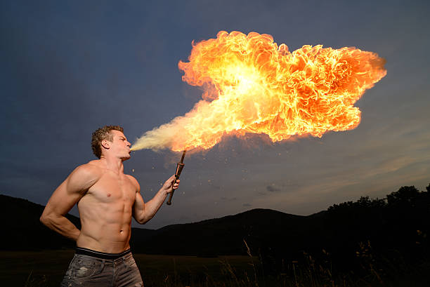 fuego ventilación al atardecer - fire eater fire performance circus performer fotografías e imágenes de stock