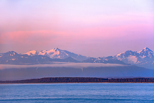 landscape of snow mountain with cloud under pink sunlight in Alaska