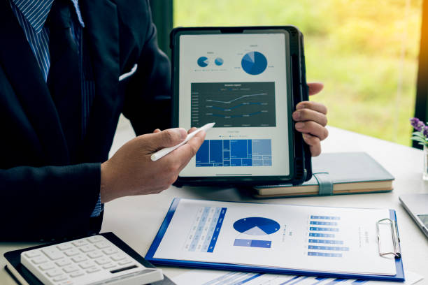istock Businessman pointing at business document for chart and graph data analysis and accounting business woman holding pen and pointing at financial documents to analyze profit concept 1810770808