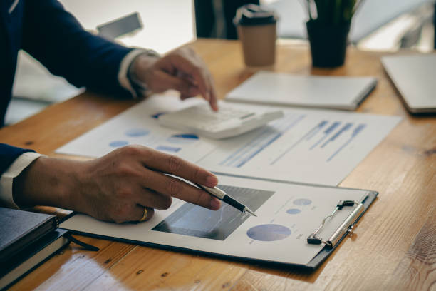istock Businessman pointing at business document for chart and graph data analysis and accounting business woman holding pen and pointing at financial documents to analyze profit concept 1810771840