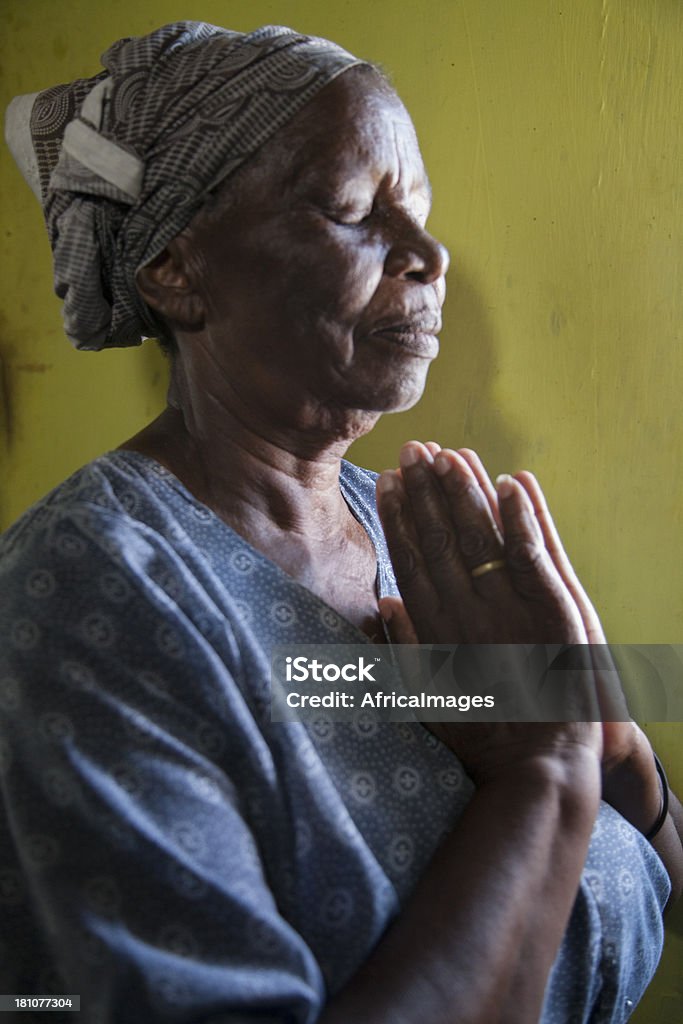 Elderly African Woman Praying , Gugulethu, Cape Town, South Africa. "Elderly African Woman Praying In Her Home , Gugulethu, Cape Town, South Africa." Close-up Stock Photo