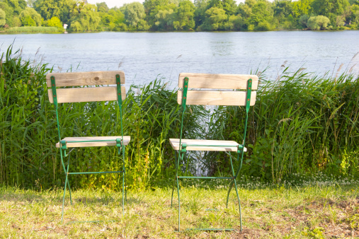 Summer in Potsdam, Germany. Riverside of the River Havel. Green lovely landscape with two chairs in the foreground.