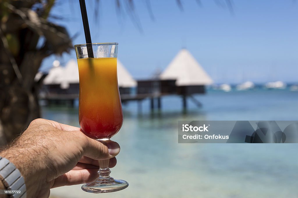 Мужчина Рука держа Coktail на тропический Пляж курорта - Стоковые фото Алкоголь - напиток роялти-фри