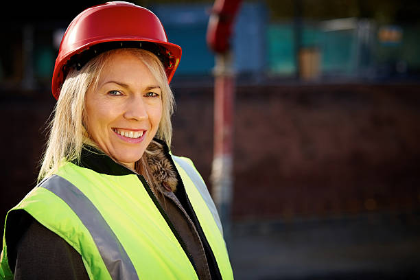 istock Female building worker on construction site smiling at camera 181078156