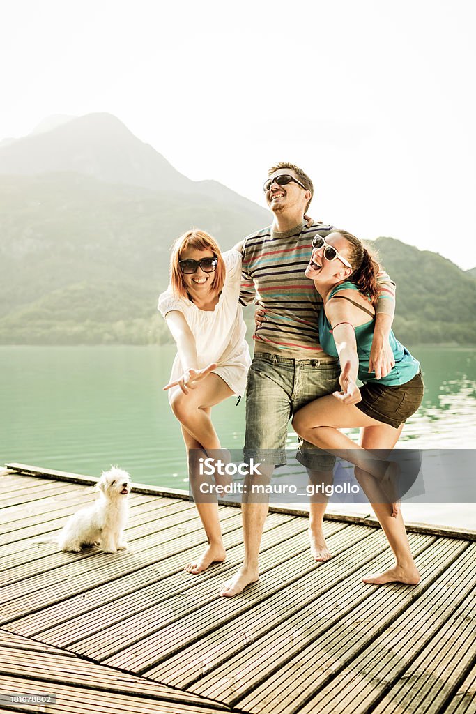 Felices amigos divirtiéndose durante un día en el lago - Foto de stock de 20 a 29 años libre de derechos