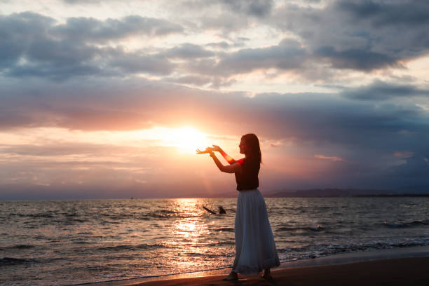 istock Beautiful lady trying to hold sun at beach 1810788941