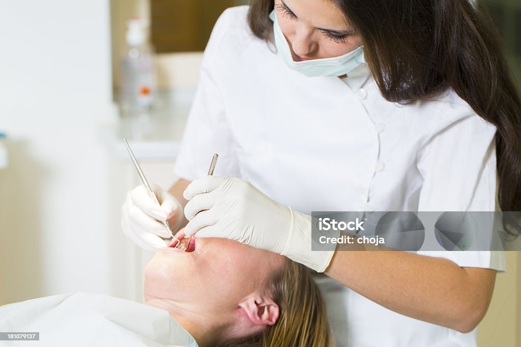 Dentista feminina trabalhando com paciente dentistas mulher na cadeira - Foto de stock de Adulto royalty-free