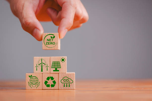 istock Net zero and carbon neutral concept. Net zero greenhouse gas emissions target. Climate neutral long term strategy. Hand put wooden cubes with green net zero icon and green icon on grey background. 1810793853