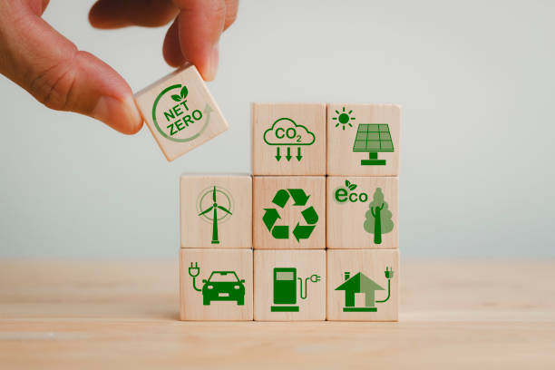 istock Net zero and carbon neutral concept. Net zero greenhouse gas emissions target. Climate neutral long term strategy. Hand put wooden cubes with green net zero icon and green icon on grey background. 1810794663