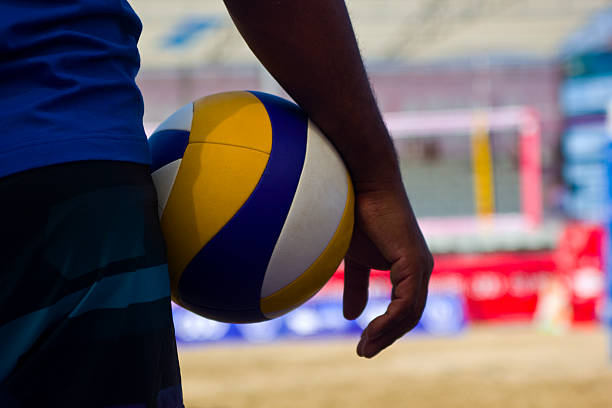 istock A volleyball player holding a volleyball under arm 181080395