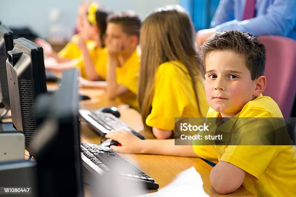 Niño En Edad Escolar En La Escuela Primaria En Clase Foto de stock y más banco de imágenes de Amarillo - Color