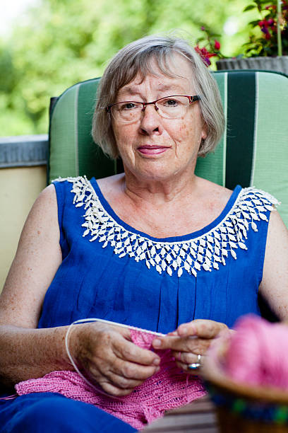 istock Senior woman sits on the balcony and knits a pullover 181080450