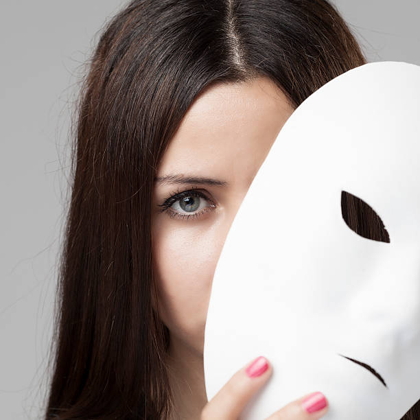 istock Woman peeking behind mask 181081367