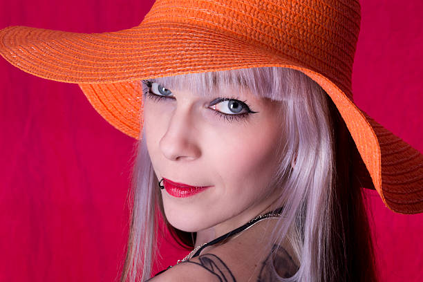 istock White haired beauty in orange hat smiling at camera. 181081670