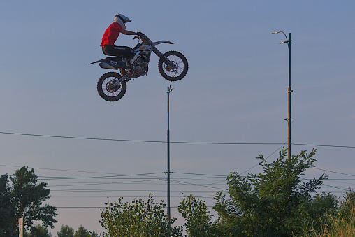 Kyiv, Ukraine - July 19, 2023: Public training in a city public park. No entrance tickets required. An unknown biker improves his high jumping skills. Unusual motorcycle control combined with a risky jump into the air. \nPark coordinates on Google map 50.492544, 30.544535 (50°29'33.2\