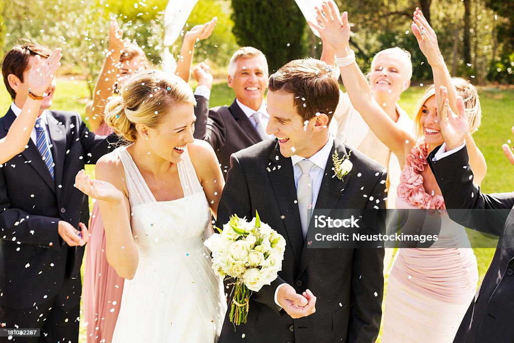 Gäste werfen Konfetti auf Paar beim Empfang im Garten - Lizenzfrei Hochzeit Stock-Foto