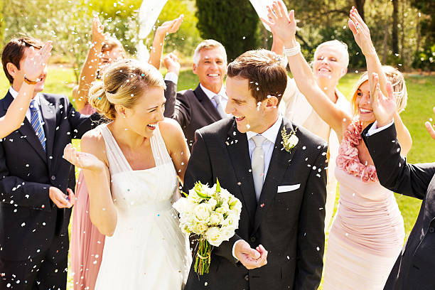 istock Guests Throwing Confetti On Couple During Reception In Garden 181082287