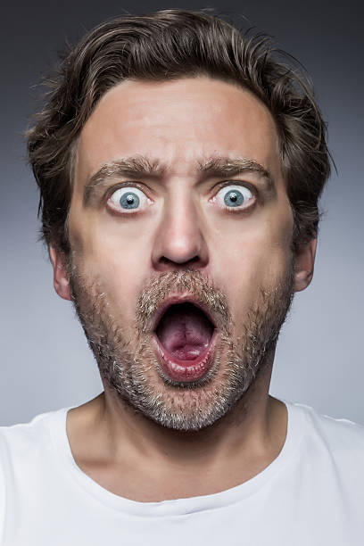 Close up of a young man looking surprised stock photo