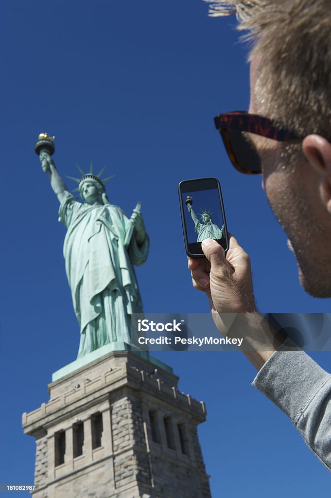 Turysta ma Smartphone zdjęcie Statua Wolności - Zbiór zdjęć royalty-free (Statua Wolności)