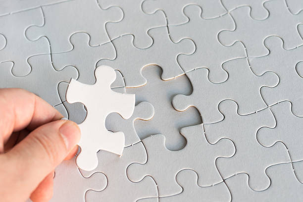 istock holding one blank white piece of jigsaw puzzle 181083241