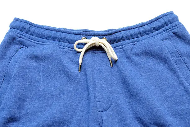 Close up of cotton sweatpants with drawstring on a white background.