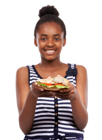 Portrait of a happy young african american girl holding a salad sandwich isolated on white