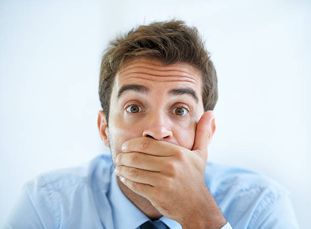 He cant believe his eyes Portrait of a young businessman covering his mouth with his hand man regret stock pictures, royalty-free photos & images