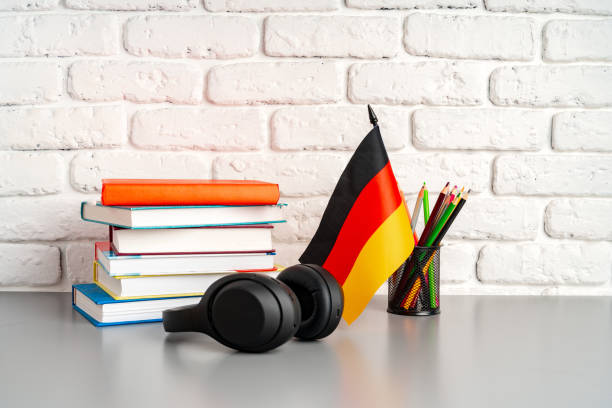 istock Stack of books and flag of Germany on desk. German language learning concept 1810860303