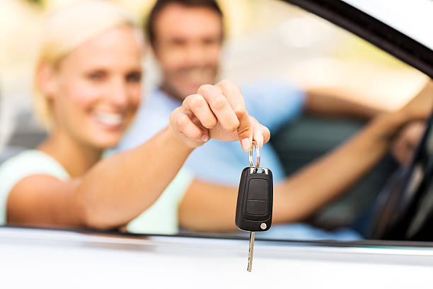 istock Woman Showing Key While Sitting With Man In Car 181086090